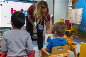 A Preschool teacher working with a student.